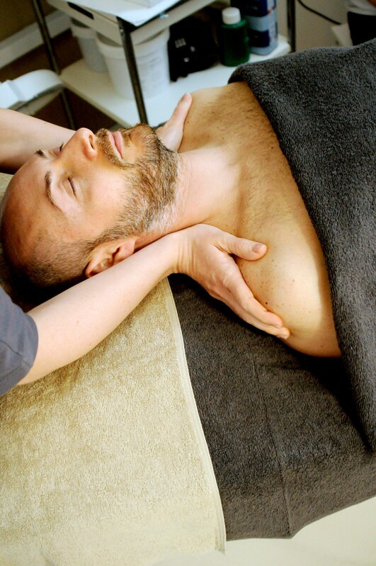 Shiatsu therapist performing a neck and shoulder treatment to support the mind-body connection and relieve tension
